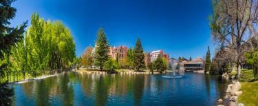 Large building located on the waterfront of a beautiful lake.