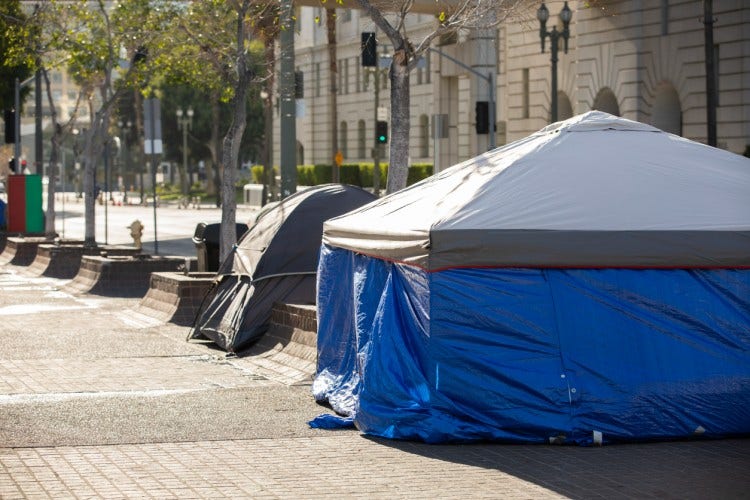 A pair of tents on a city sidewalk.