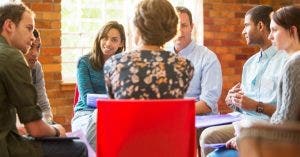A social worker leads a group therapy session.