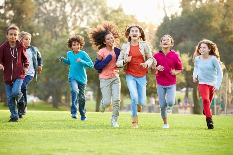 A group of adolescents running in a park.